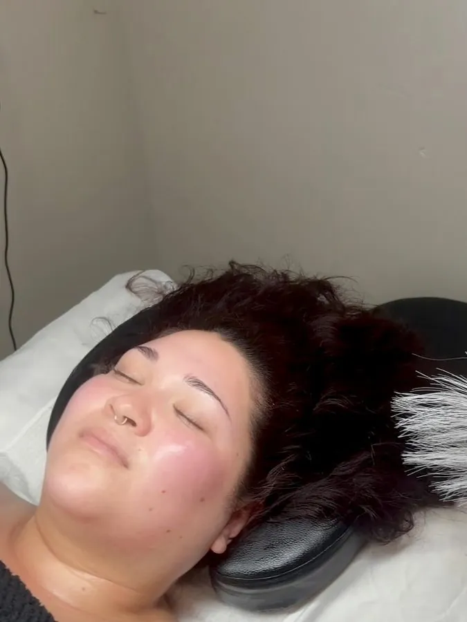 Client glowing after a customized facial, resting on the treatment bed