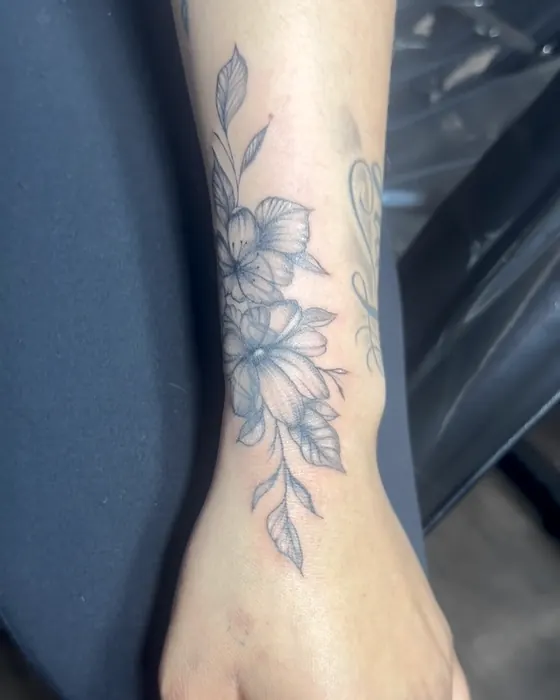 Fine line floral running from the wrist up the forearm
