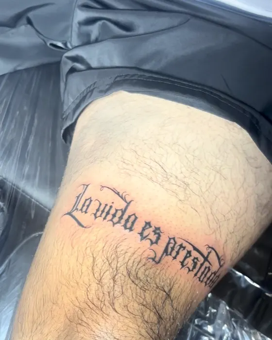 Script lettering reading La vida es preciosa on the thigh