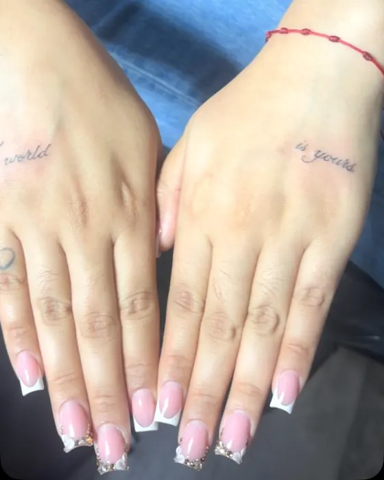 Tiny fine line script on the sides of two hands