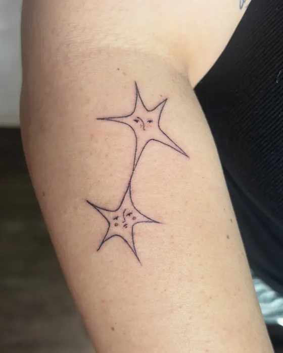 Two linked fine line stars on the arm