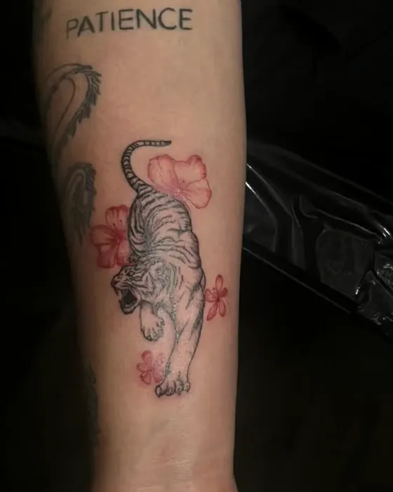 Tiger with red flowers on the forearm