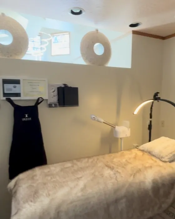 The BB Beauty treatment room with a facial bed, round mirrors and warm lighting