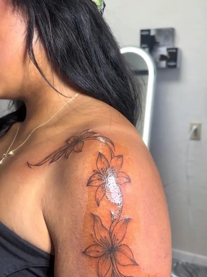 Fine line lilies and flourishes on the shoulder