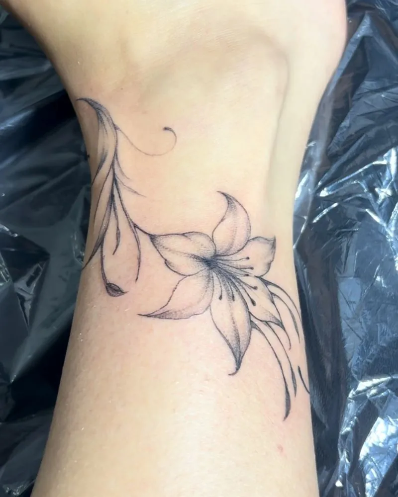 Fine line lily tattoo with long flowing stems, by Isabella Kelly in Orcutt